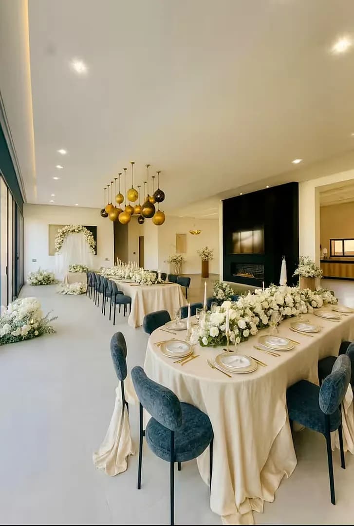 Une longue table dressée dans le salon des Domaines du Sahara, prête pour un déjeuner de groupe